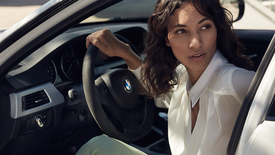 BMW Value Service BMW Service, stranka gleda skozi odprta vrata svojega BMW