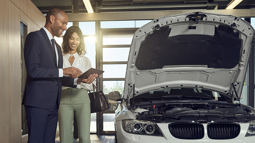 Pregled in vzdrževanje BMW Service, stranka in zaposleni BMW Service se pogovarjajo o pregledu in vzdrževanju