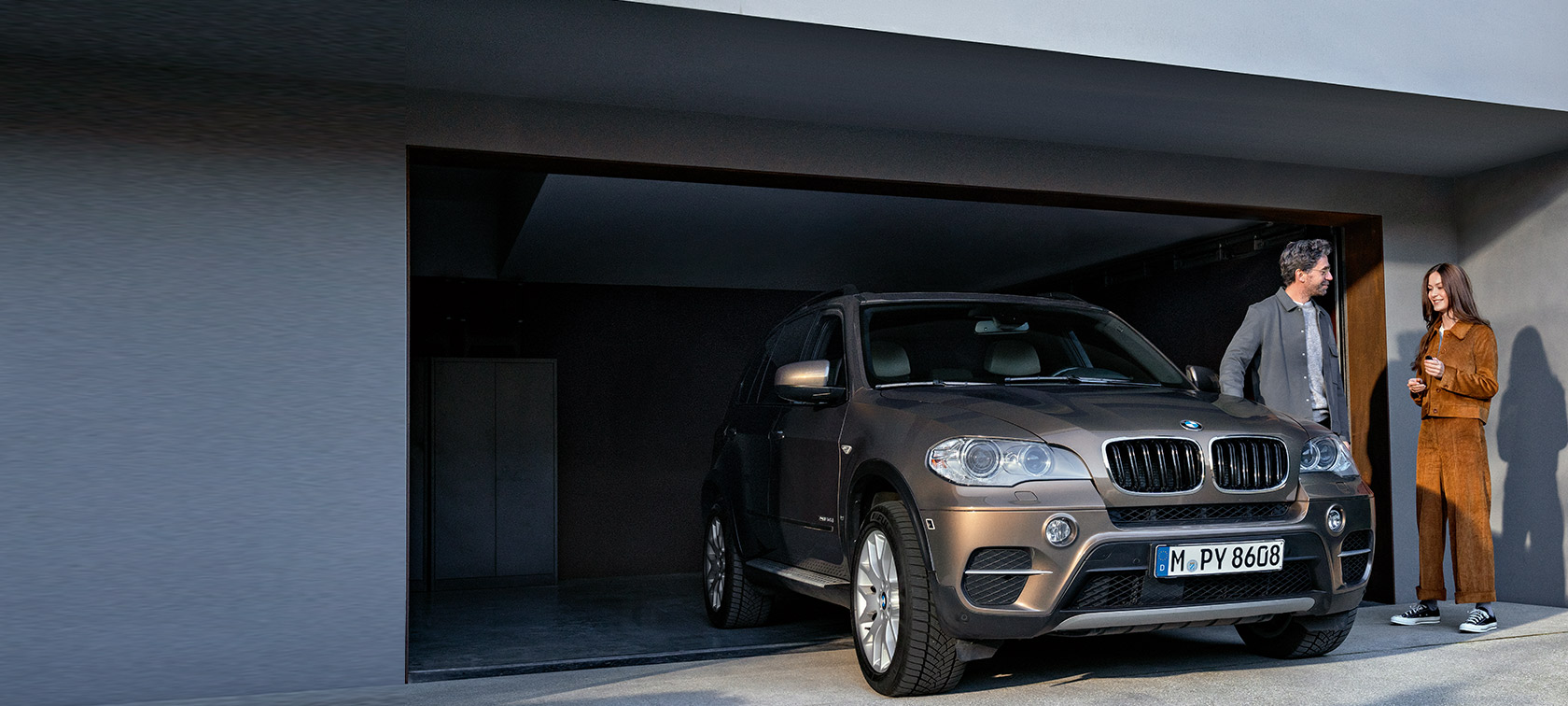 BMW Service 5+ BMW Service 5+, moški in ženska pred garažo z BMW X5