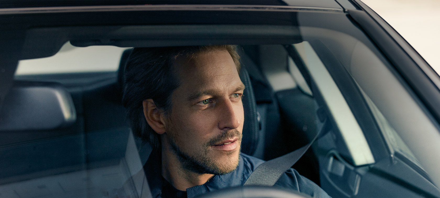 Man driving BMW thanks to BMW Service Inclusive BMW Service Inclusive Man driving BMW looking through windshield