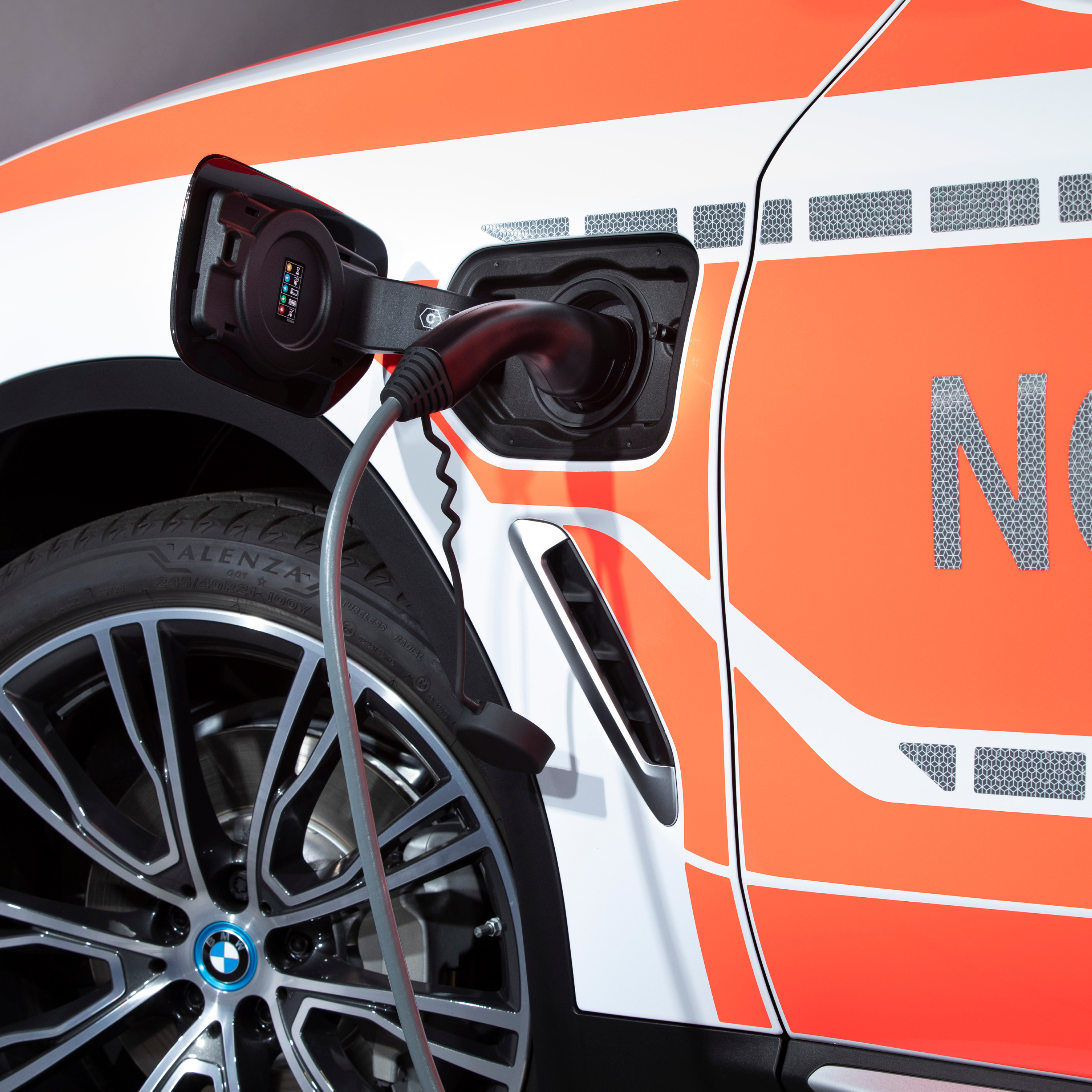Vozilo za javne službe BMW kot priključni hibrid med polnjenjem; bližnji pogled polnilnega kabla